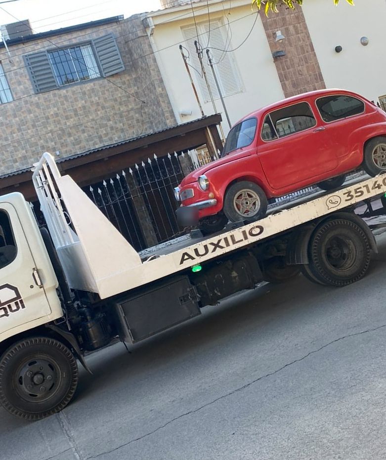 Fiat 600 rojo sobre la grúa
